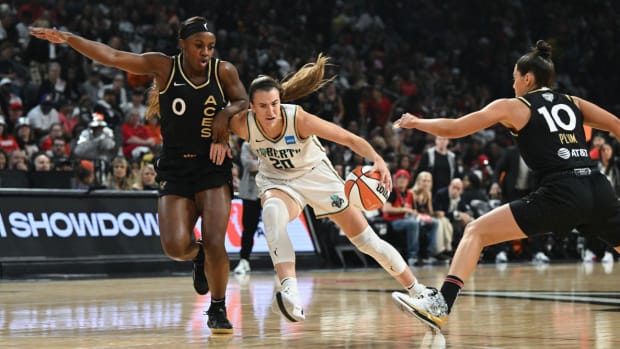 New York Liberty guard Sabrina Ionescu drives past Las Vegas Aces guards Jackie Young and Kelsey Plum in Game 1 of the WNBA Finals.